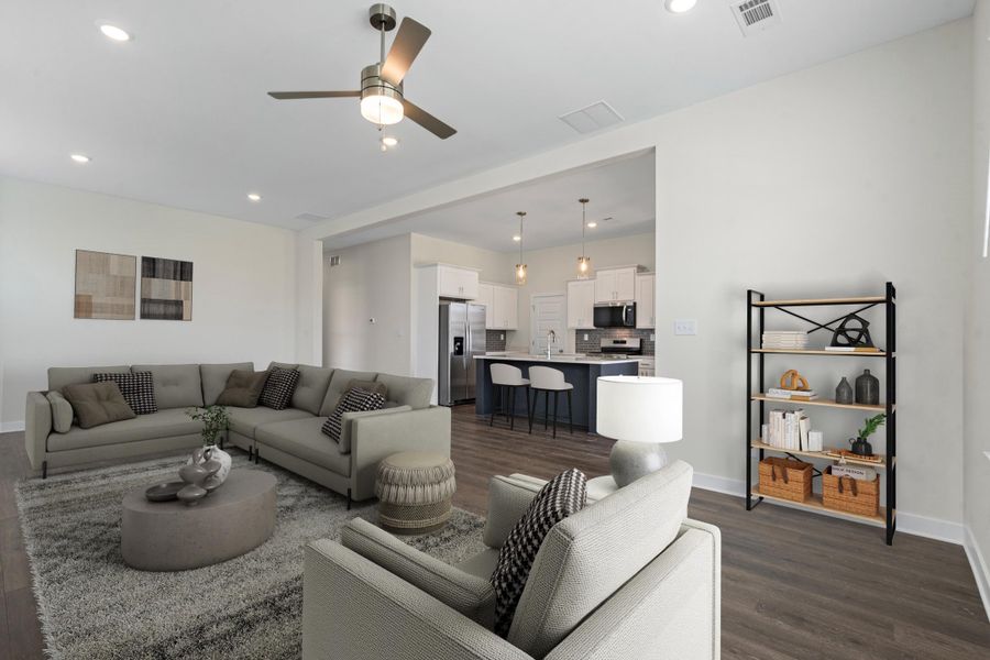 Open-concept living area featuring wood-finish flooring, a contemporary ceiling fan, and recessed lighting Open-concept living area featuring wood-finish flooring, a contemporary ceiling fan, and recessed lighting