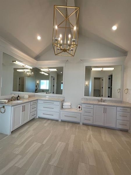 Bathroom featuring vanity, ceiling fan, and high vaulted ceiling