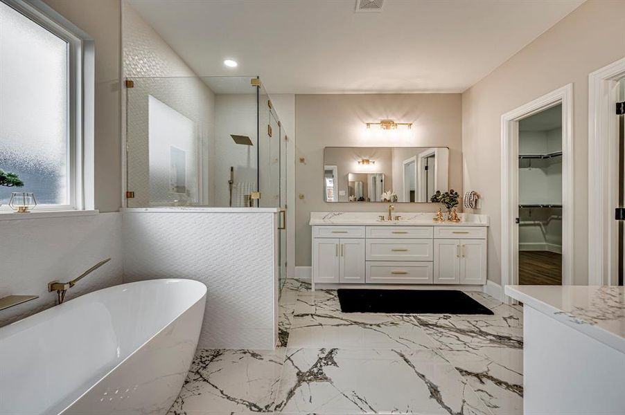 Bathroom featuring shower with separate bathtub and vanity