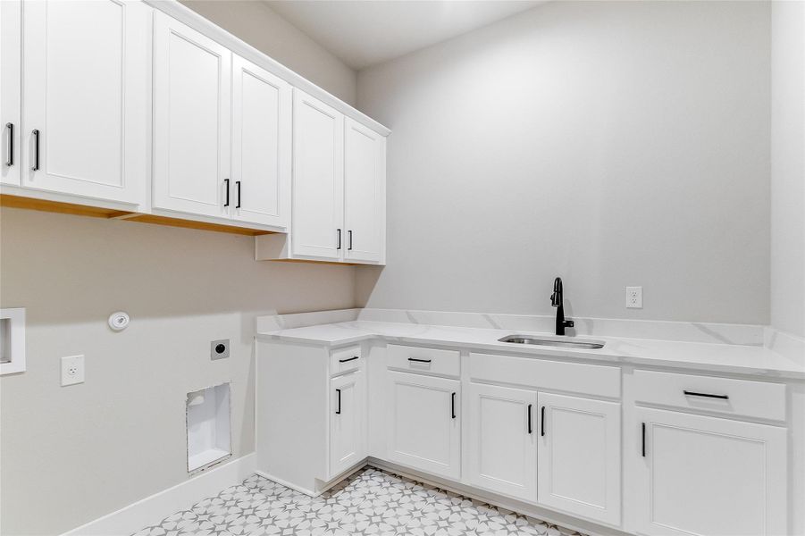 Laundry area with hookup for a gas dryer, cabinet space, electric dryer hookup, and washer hookup