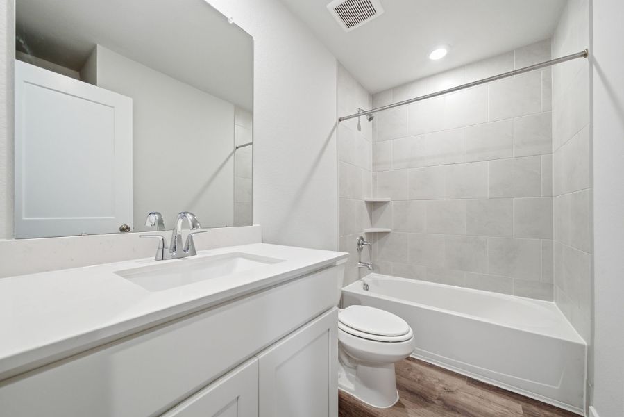 A bathroom with a tub sink and toilet.