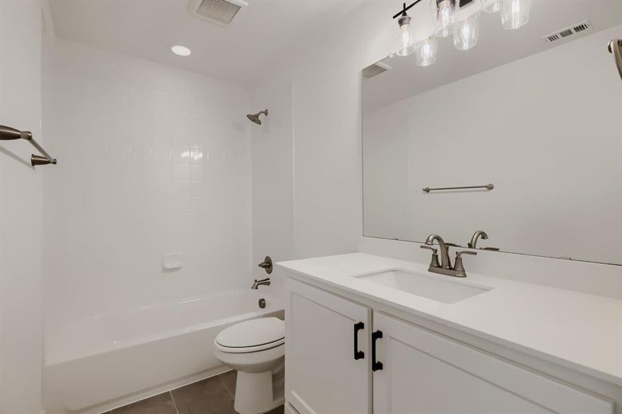 Bathroom vanity with white cabinetry, matte black hardware, and a white countertop with an integrated sink Bathroom vanity with white cabinetry, matte black hardware, and a white countertop with an integrated sink