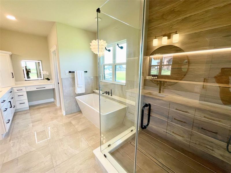 Bathroom with tile walls, independent shower and bath, vanity, and tile patterned floors