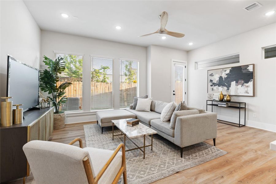 Defined by its scale and light, the living room is anchored by a wall of picture-style windows that enhance both openness and connection to the outdoors.