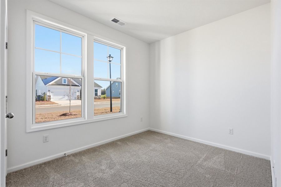 Carpeted spare room with baseboards
