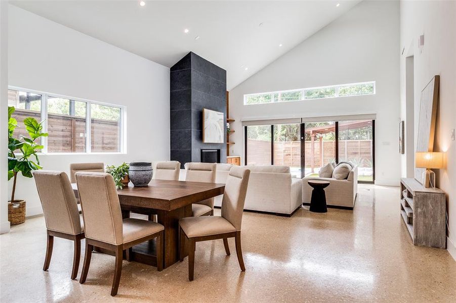 Dining room featuring high vaulted ceiling and a fireplace