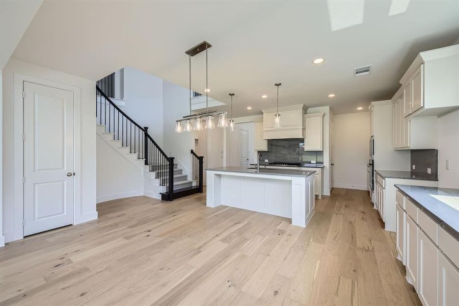 Kitchen featuring decorative backsplash, light wood-type flooring, stainless steel oven, recessed lighting, and baseboards Kitchen featuring decorative backsplash, light wood-type flooring, stainless steel oven, recessed lighting, and baseboards