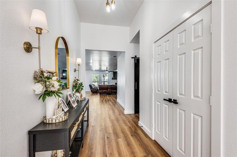 Corridor with a barn door and light wood-style floors