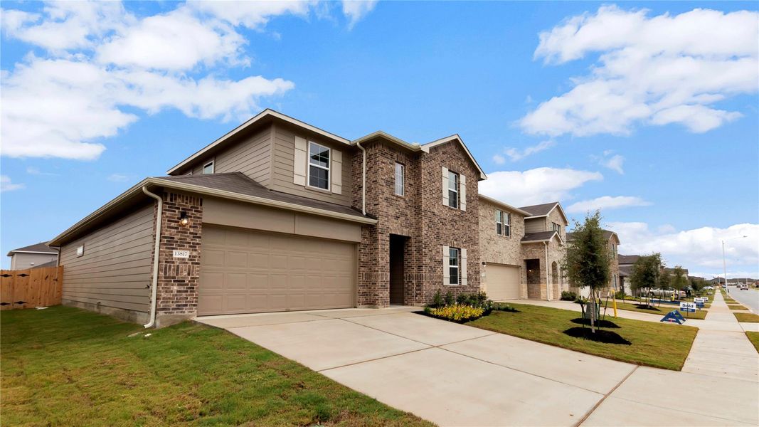 Front exterior of a new home in Carillon, Manor, TX, highlighting curb appeal (Image 1).