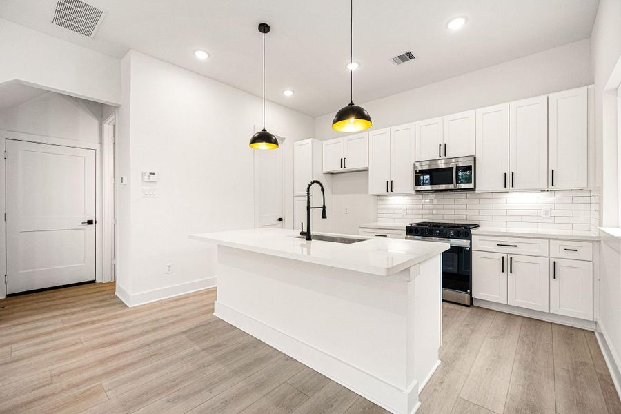 This kitchen is a chef’s dream, blending elegance with functionality! Soaring ceilings and bright white cabinetry create an open, airy feel, while stunning Quartz countertops and a sleek subway tile backsplash add a touch of modern sophistication. Stainless steel appliances, recessed lighting, and custom pendant fixtures elevate the space, making it as beautiful as it is practical. The oversized Quartz island, complete with a double sink and breakfast bar seating, is perfect for entertaining. This kitchen is a chef’s dream, blending elegance with functionality! Soaring ceilings and bright white cabinetry create an open, airy feel, while stunning Quartz countertops and a sleek subway tile backsplash add a touch of modern sophistication. Stainless steel appliances, recessed lighting, and custom pendant fixtures elevate the space, making it as beautiful as it is practical. The oversized Quartz island, complete with a double sink and breakfast bar seating, is perfect for entertaining.