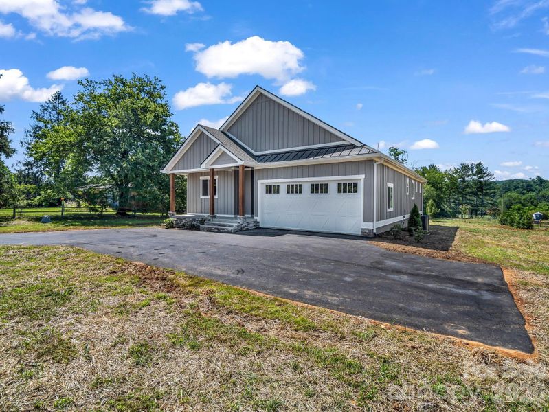 Front view of custom modern farmhouse, 2 car attached garage, covered front porch and hardyboard siding, oversized driveway for ample parking Front view of custom modern farmhouse, 2 car attached garage, covered front porch and hardyboard siding, oversized driveway for ample parking