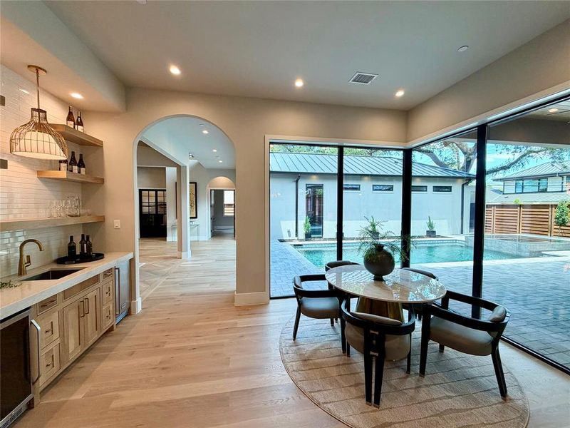 Expansive glass walls overlook a paver patio and swimming pool Expansive glass walls overlook a paver patio and swimming pool