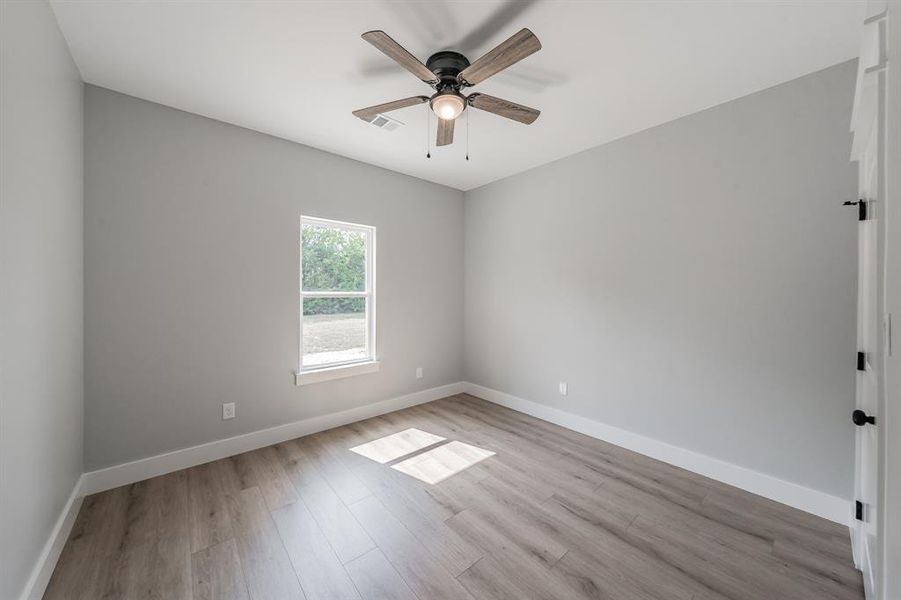 Spare room with light wood-type flooring and ceiling fan