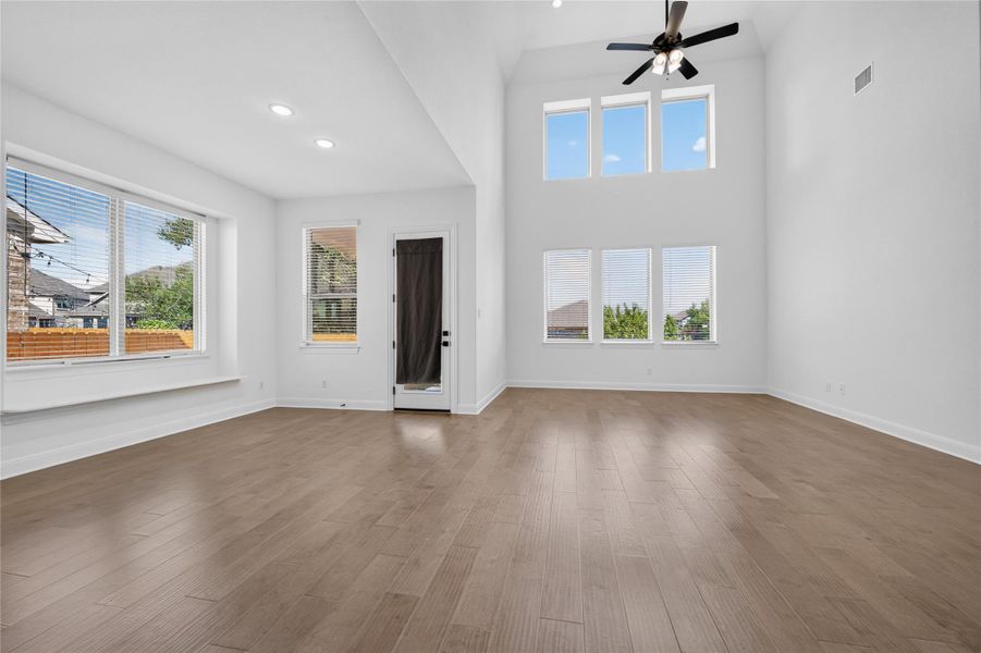 Hardwood floors and towering windows highlight this open-concept living area. Hardwood floors and towering windows highlight this open-concept living area.