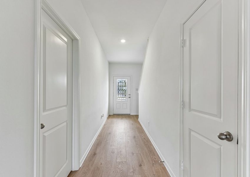 Foyer entry hallway featuring wood-look vinyl flooring and a sightline into the home.