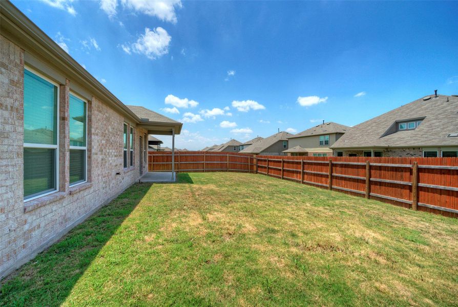 A spacious backyard with a sturdy wooden fence, offering ample room for outdoor activities. A spacious backyard with a sturdy wooden fence, offering ample room for outdoor activities.
