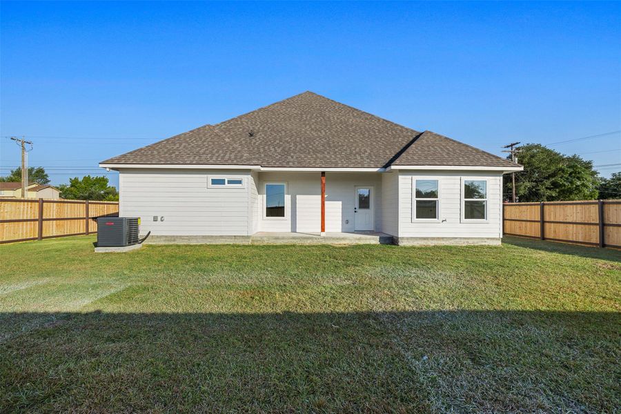 Rear view of property with roof with shingles, a patio area, and a fenced backyard Rear view of property with roof with shingles, a patio area, and a fenced backyard