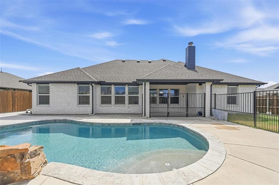 Back of property with a fenced backyard, a patio, roof with shingles, and brick siding Back of property with a fenced backyard, a patio, roof with shingles, and brick siding