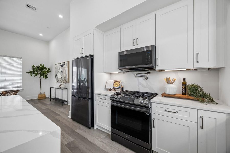 The kitchen has a French door refrigerator and black toned appliances. The kitchen has a French door refrigerator and black toned appliances.