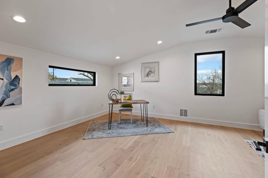 Office area featuring vaulted ceiling, ceiling fan, light wood-style flooring, recessed lighting, and baseboards