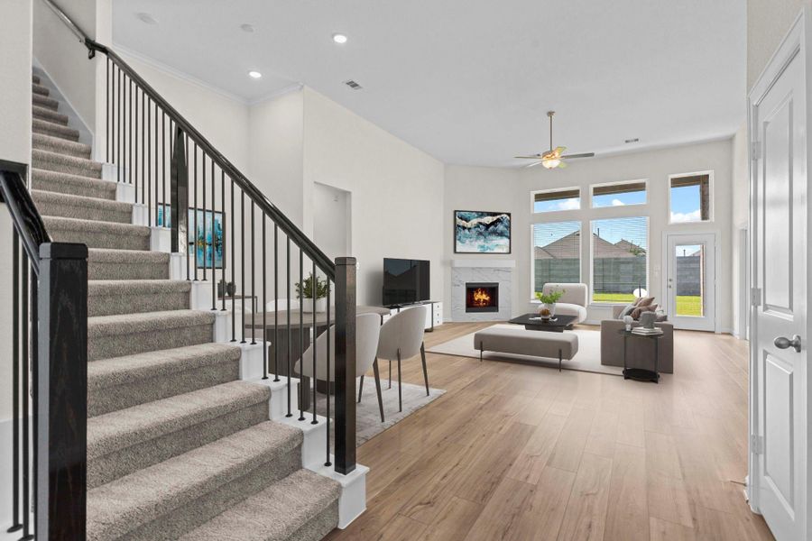 Striking staircase with wrought iron railing opens into the expansive family room, complete with tall ceilings, gas fireplace, and large windows. Look at those amazing carefree large tile plank floors throughout the first floor. *Virtually Staged* Striking staircase with wrought iron railing opens into the expansive family room, complete with tall ceilings, gas fireplace, and large windows. Look at those amazing carefree large tile plank floors throughout the first floor. *Virtually Staged*