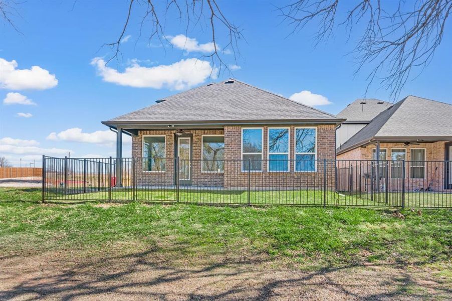 Rear view of property with roof with shingles, a patio area, and brick siding