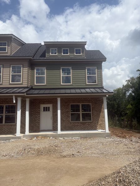 As of July 8, 2026, the current progress is as pictured. The house is situated on a corner lot, surrounded by lush greenery and a tree line.