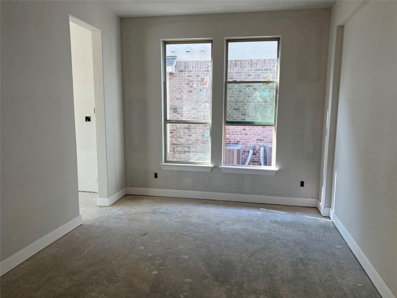 Unfurnished room with baseboards, concrete flooring, and a wealth of natural light Unfurnished room with baseboards, concrete flooring, and a wealth of natural light