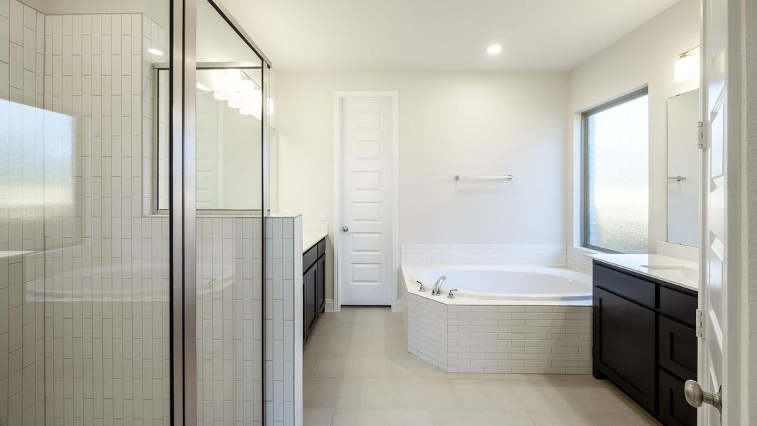 Bathroom featuring vanity, a bath, a shower stall, tile patterned floors, and recessed lighting Bathroom featuring vanity, a bath, a shower stall, tile patterned floors, and recessed lighting