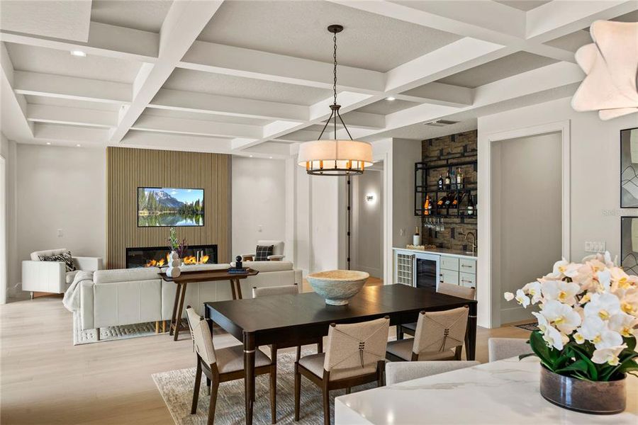 Open floor plan with coffered ceiling and electric fireplace. CUSTOM CABINETRY & SHELVES FLANKING THE FIREPLACE ARE BEING ADDED. Open floor plan with coffered ceiling and electric fireplace. CUSTOM CABINETRY & SHELVES FLANKING THE FIREPLACE ARE BEING ADDED.