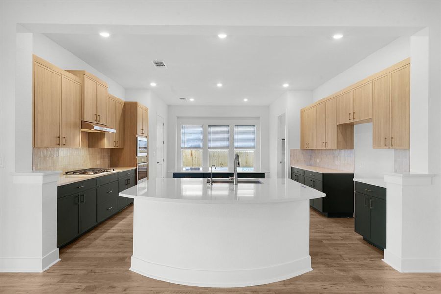 Culinary creations come to life in this kitchen, featuring an oversized island and modern finishes.