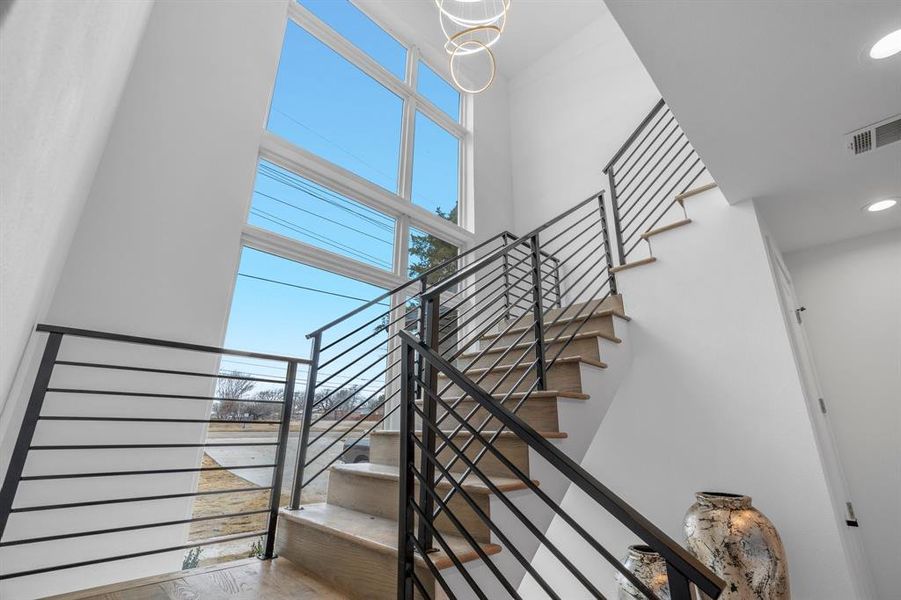 Stairs featuring a towering ceiling and a chandelier