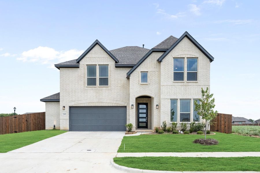 Two-story brick home with dark gray roof, two-car garage, arched entry, and manicured front lawn Two-story brick home with dark gray roof, two-car garage, arched entry, and manicured front lawn
