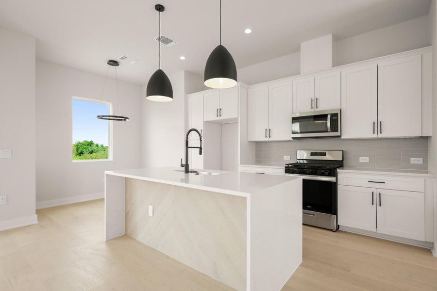 Kitchen featuring backsplash, appliances with stainless steel finishes, an island with sink, light stone counters, and recessed lighting Kitchen featuring backsplash, appliances with stainless steel finishes, an island with sink, light stone counters, and recessed lighting