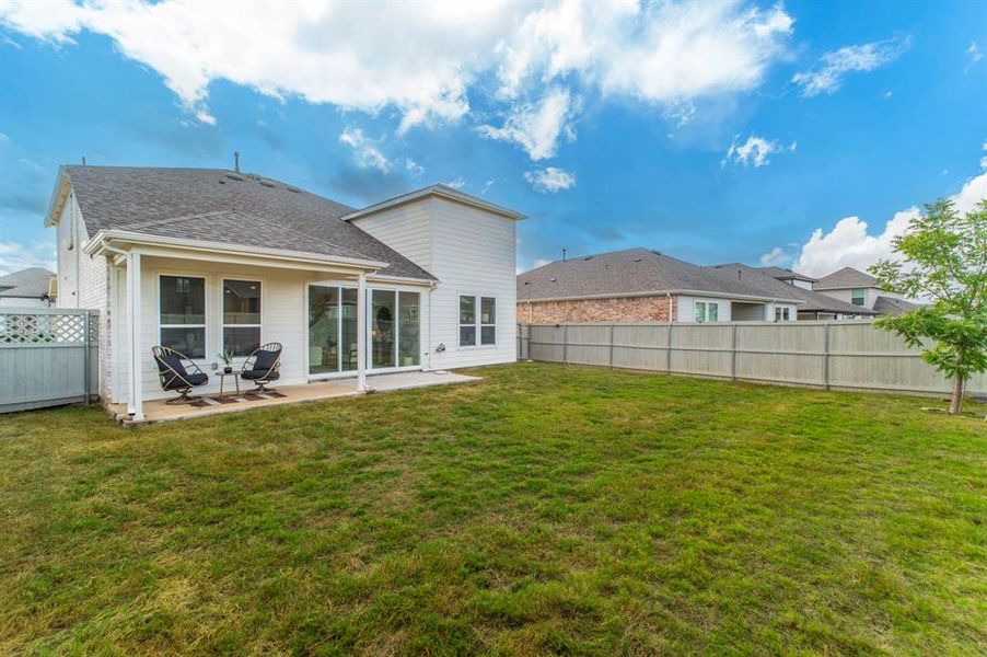 Back of property featuring a fenced backyard, a patio, and a shingled roof Back of property featuring a fenced backyard, a patio, and a shingled roof