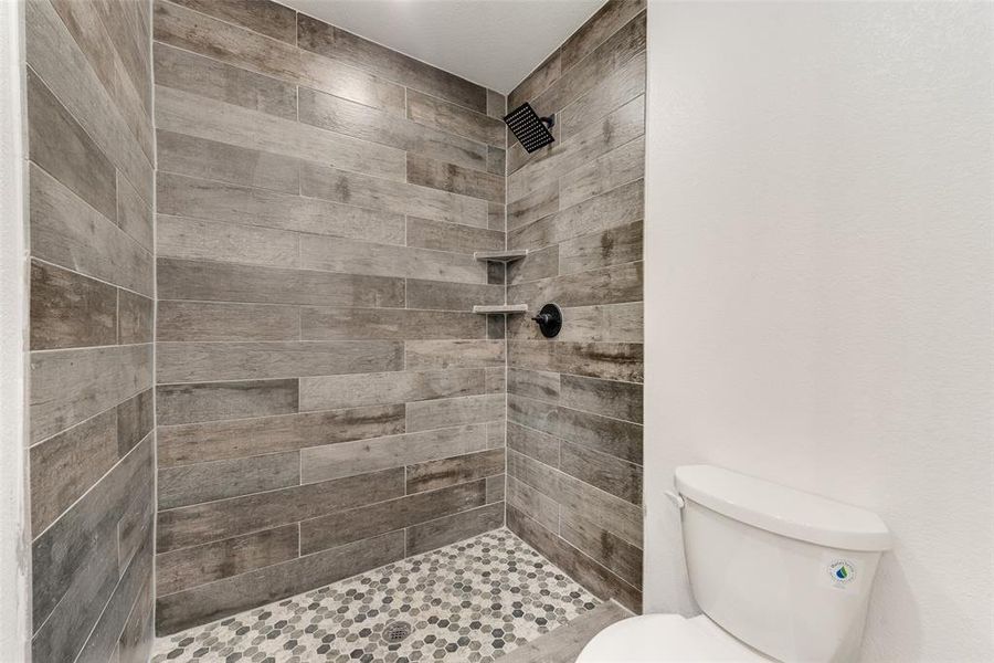 Bathroom with tiled shower and toilet