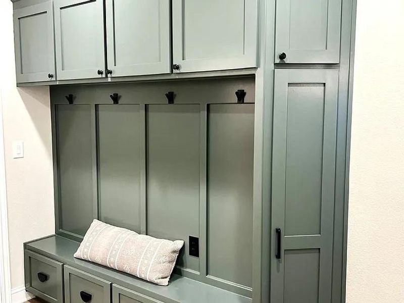 Built-in cabinetry with a bench, integrated coat hooks, upper storage, and lower drawer storage Built-in cabinetry with a bench, integrated coat hooks, upper storage, and lower drawer storage