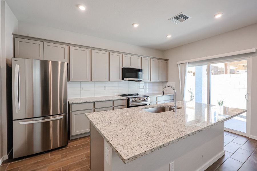 A kitchen with white cabinets.