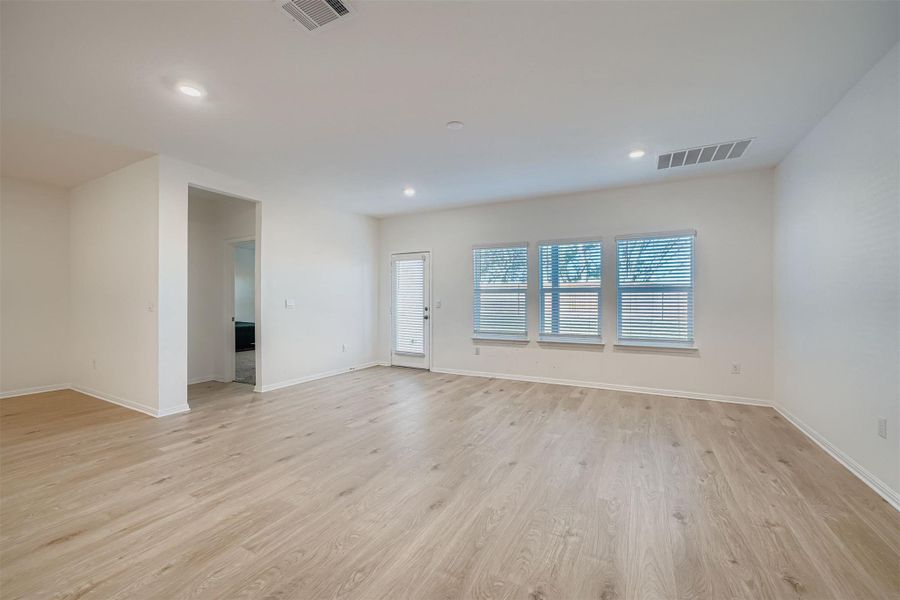 Empty room with light wood-style flooring and recessed lighting
