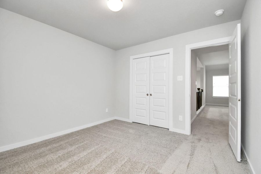 Generously sized secondary bedrooms, complete with spacious closets and soft, inviting carpeting. Sample photo of completed home with similar floor plan. Actual colors and selections may vary.