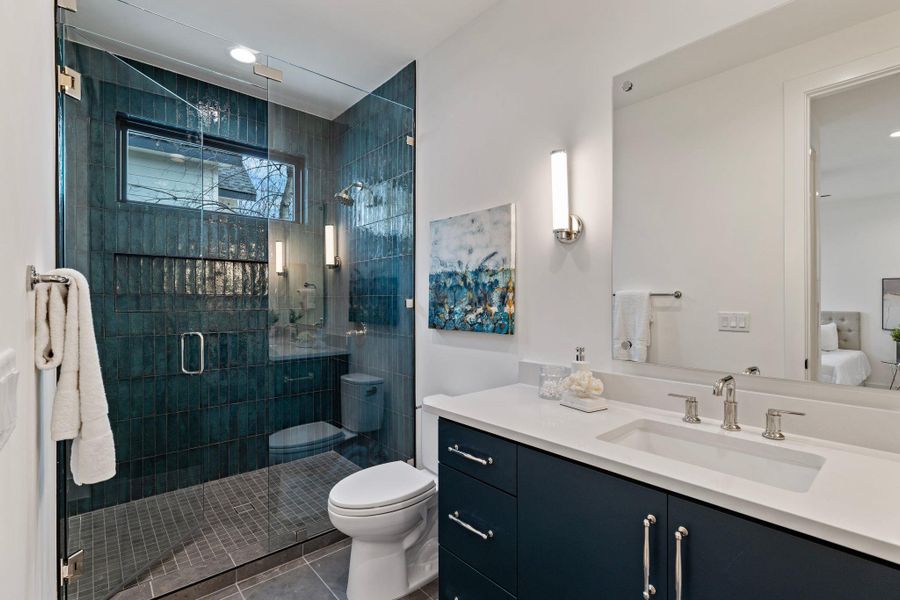 Bathroom featuring vanity, toilet, tile patterned floors, and a shower stall