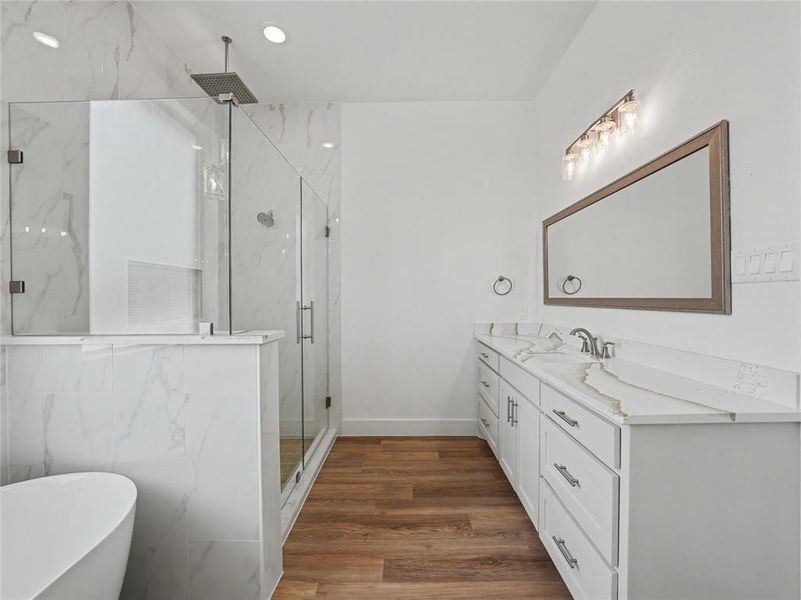 Modern bathroom featuring a glass-enclosed shower with rain showerhead, freestanding soaking tub, and double vanity with dual sinks