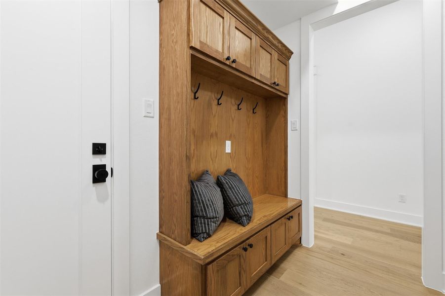 Step inside from the garage into a mudroom featuring white oak built ins, thoughtfully appointed with hooks and closed storage to maximize functionality and everyday organization.