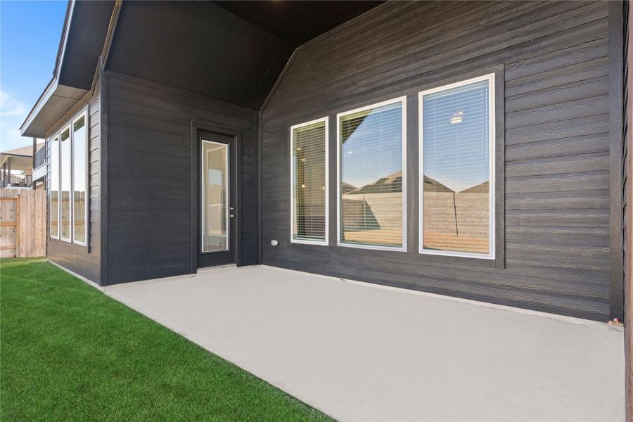 A closer look at the covered patio showcases a wonderful outdoor living area just steps from the home, ideal for relaxing or hosting gatherings, with easy access to the backyard and a design that blends comfort and functionality for year round enjoyment.