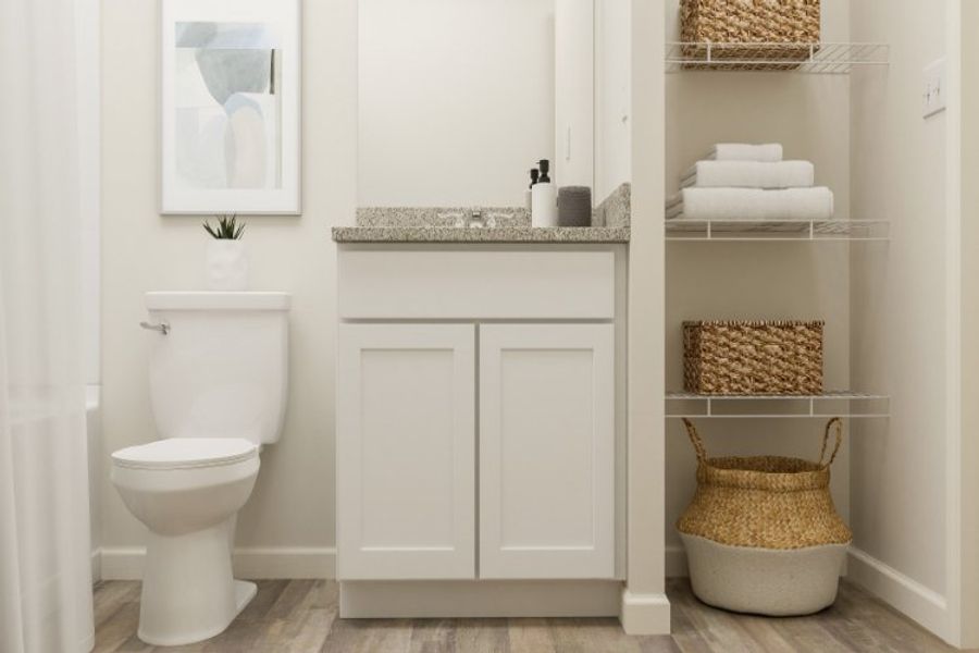 A bathroom with a toilet and a shelf with towels.