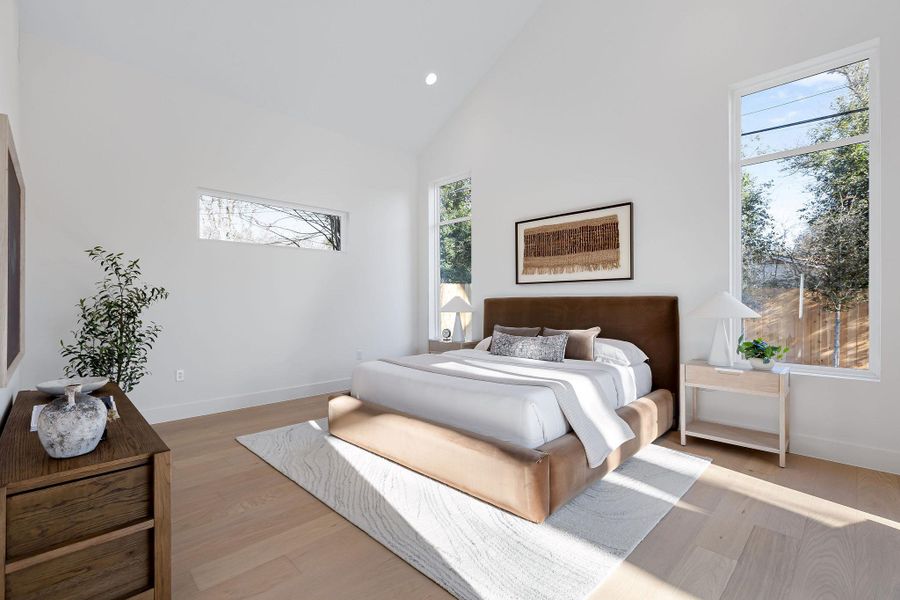 Bedroom with lofted ceiling, light wood-style floors, and recessed lighting
