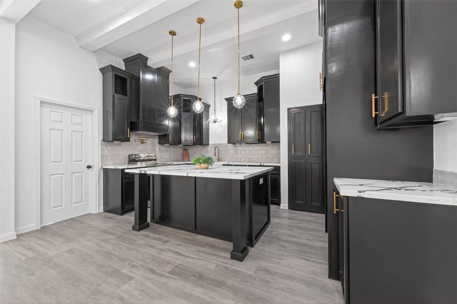 Stunning chef’s kitchen with oversized island, abundant custom cabinetry, modern finishes, and ample prep space for everyday living.