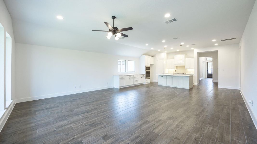 Unfurnished living room featuring recessed lighting, dark wood-style floors, a ceiling fan, and lofted ceiling Unfurnished living room featuring recessed lighting, dark wood-style floors, a ceiling fan, and lofted ceiling