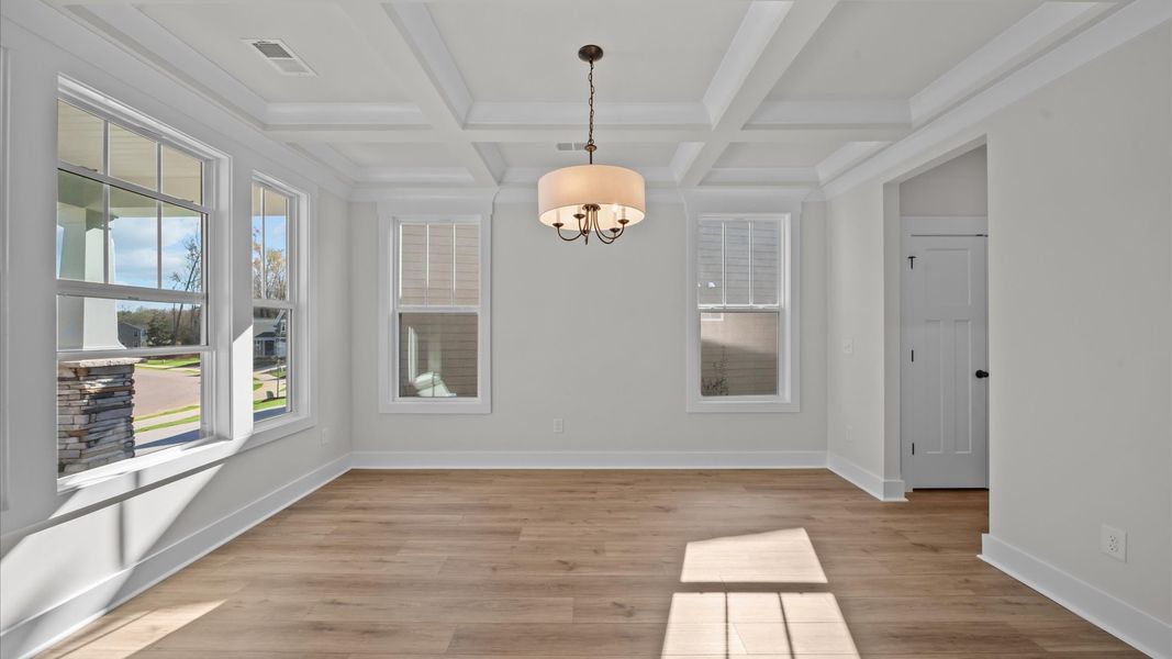 Desirable dining room with coffered ceiling and modern elegance in an established community Desirable dining room with coffered ceiling and modern elegance in an established community