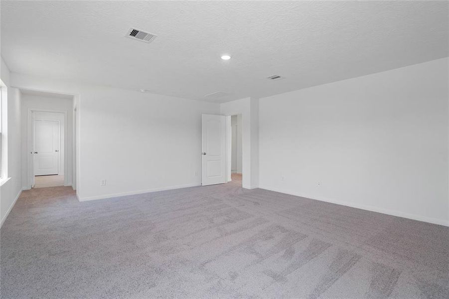 Another view of this primary suite looking into the primary bathroom.